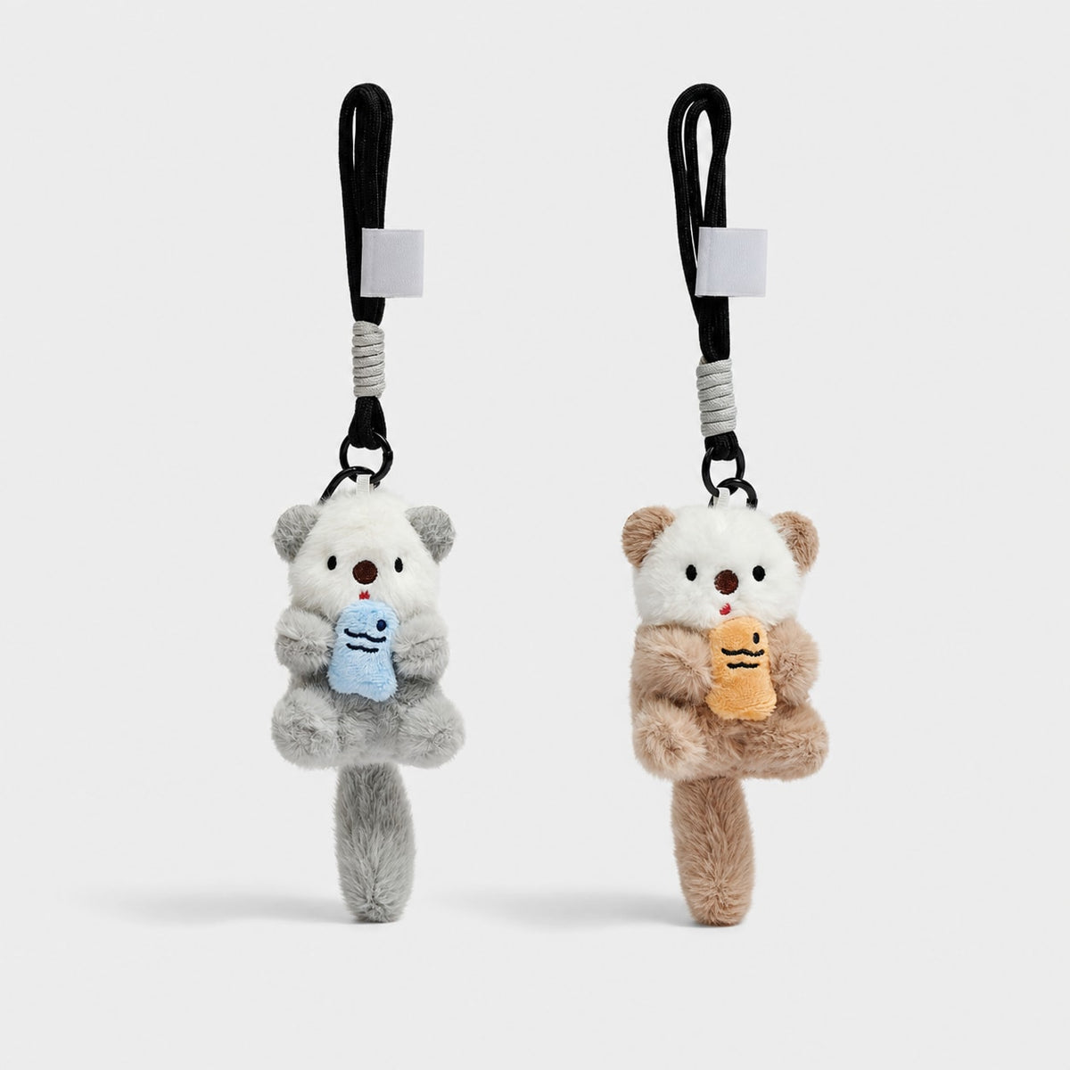 Gray and brown otter plush bag charm color options shown together; each charm sold separately.